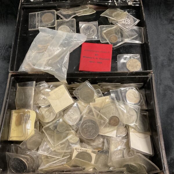 Large cash tin filled with a diverse coin collection.