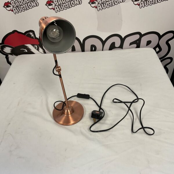Vintage copper desk lamp with adjustable angle for task lighting.