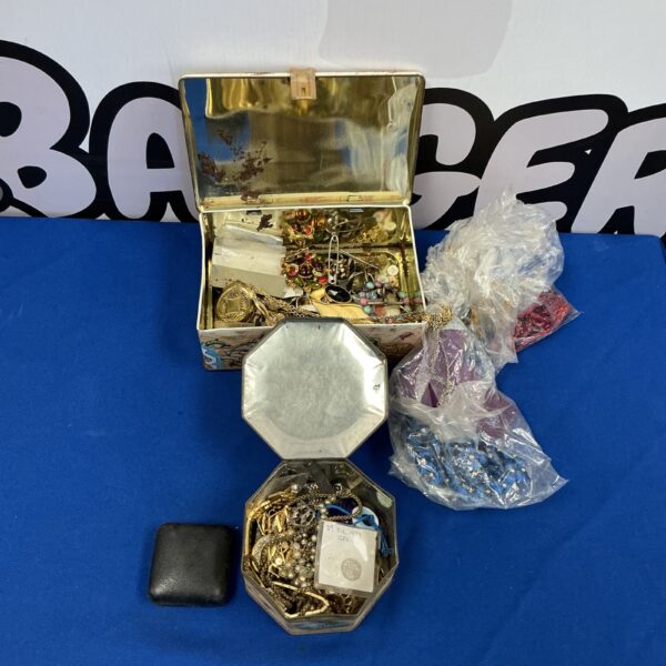 Two tins filled with a colourful assortment of vintage costume jewellery.