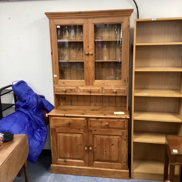 Country pine dresser with glass cabinets for display and storage.