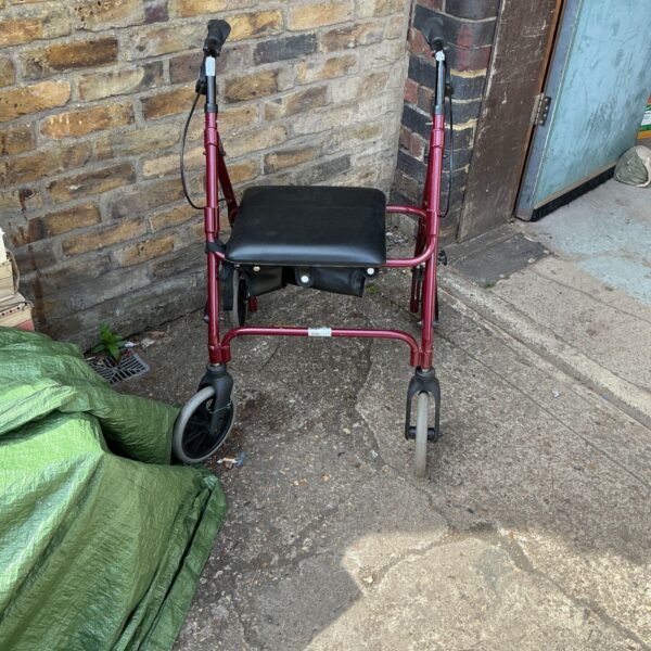 Red Days walking aid trolley with a padded seat.