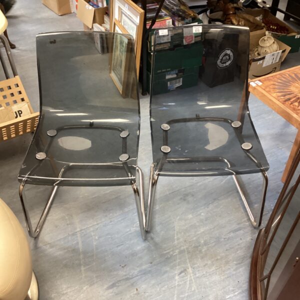 Pair of clear acrylic designer chairs with modern styling.
