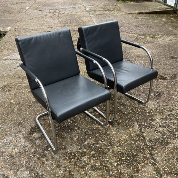 Two black designer reception chairs with chrome frames.