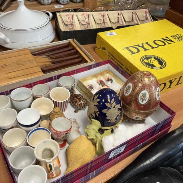 Vintage egg cups and mixed collectibles in a box.