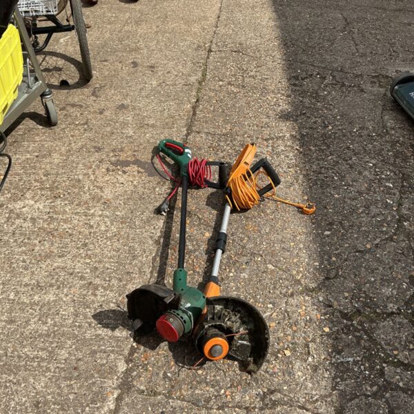 Used electric garden strimmer with orange cable for garden maintenance.