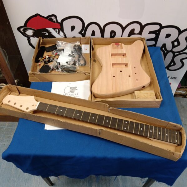 Unfinished electric guitar kit with body, neck, and hardware.