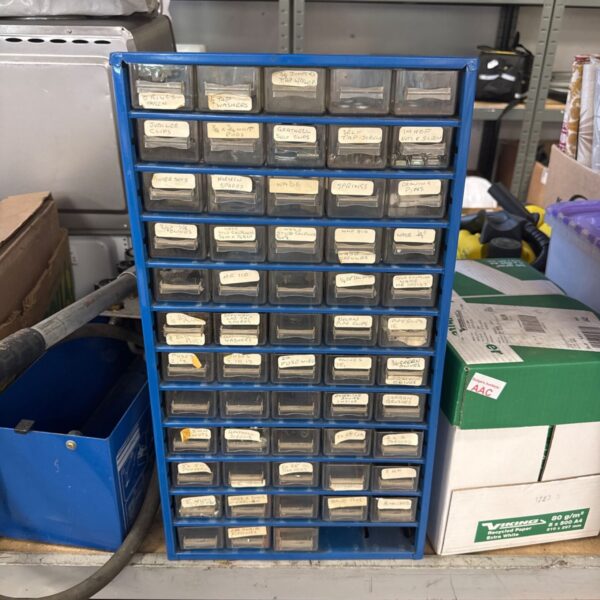 Blue metal engineers parts storage cabinet with labelled drawers.