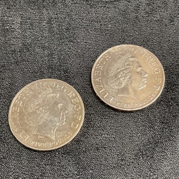 Two UK five pound coins featuring Elizabeth II portrait.