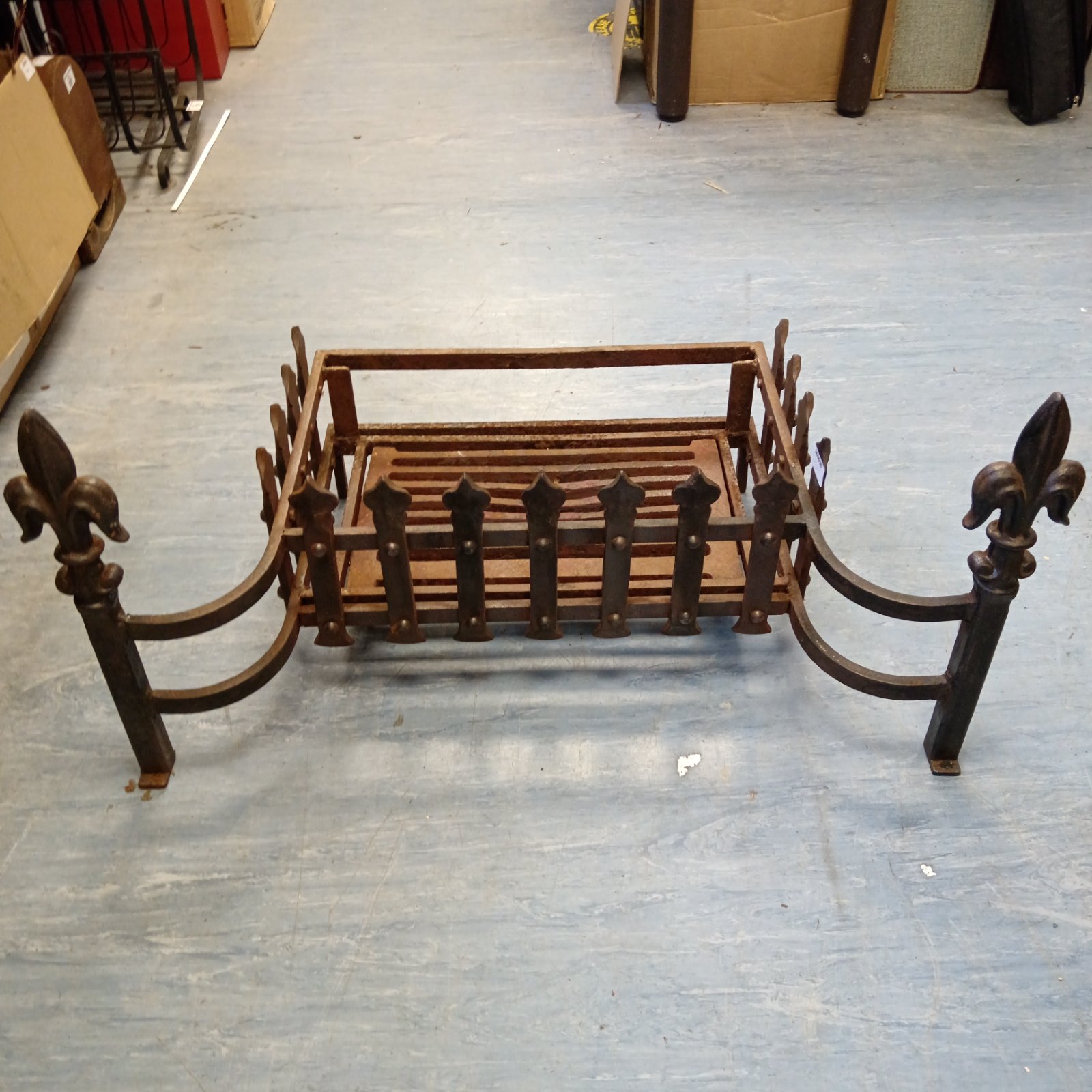 Antique wrought iron fire grate with Fleur de Lis design.