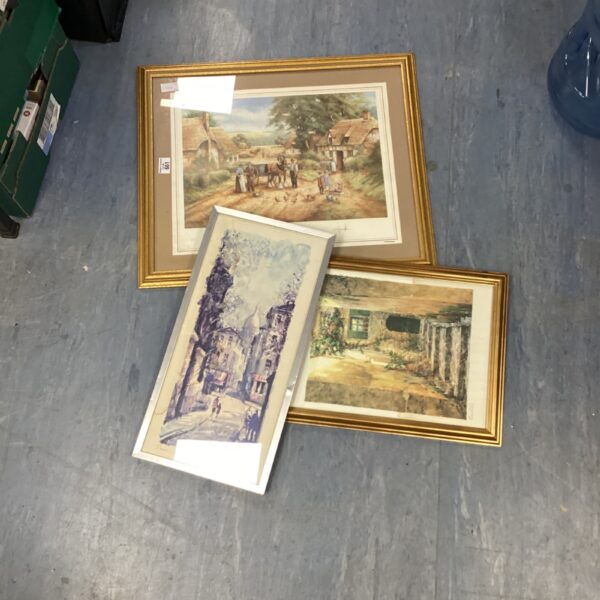 Three framed farmhouse prints depicting rural scenes.