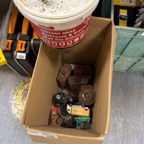 Garage clearance lot with tile adhesive and mixed hardware items.