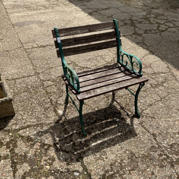 Vintage wrought iron garden bench with wooden slats.