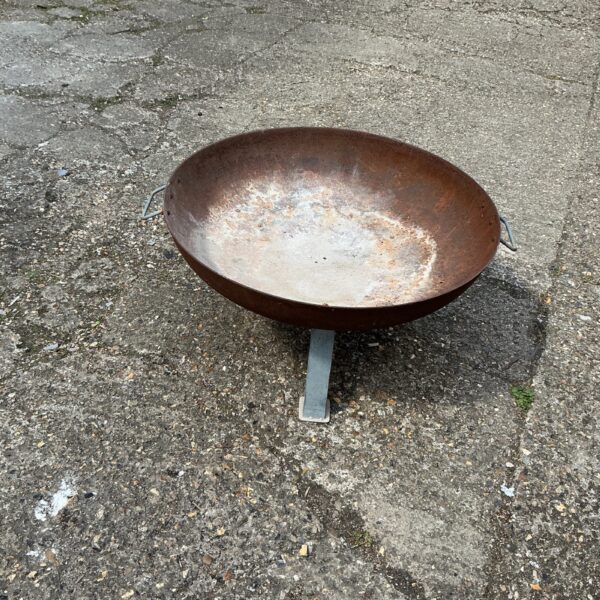 Rustic metal garden fire pit for outdoor heating and ambiance.