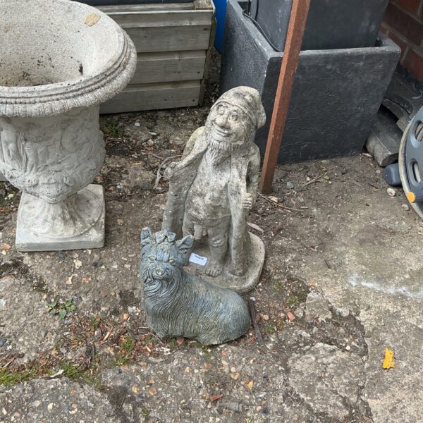 Vintage garden gnome with dog, charming garden ornament.