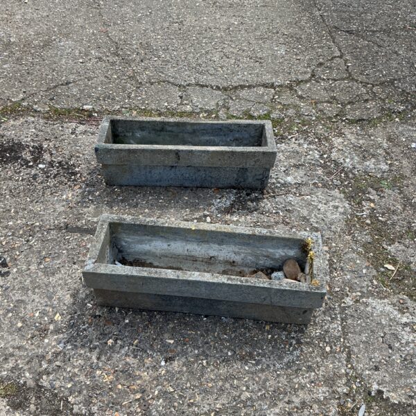 Two weathered stone garden planters for outdoor plants.