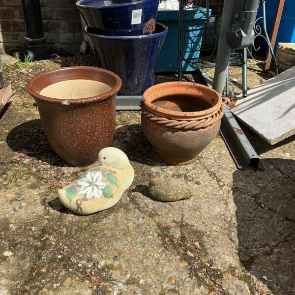 Vintage garden pots with duck figurines for outdoor decoration.