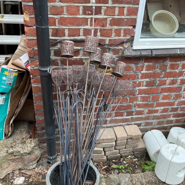 Quantity of metal garden tee light holders in a pot.