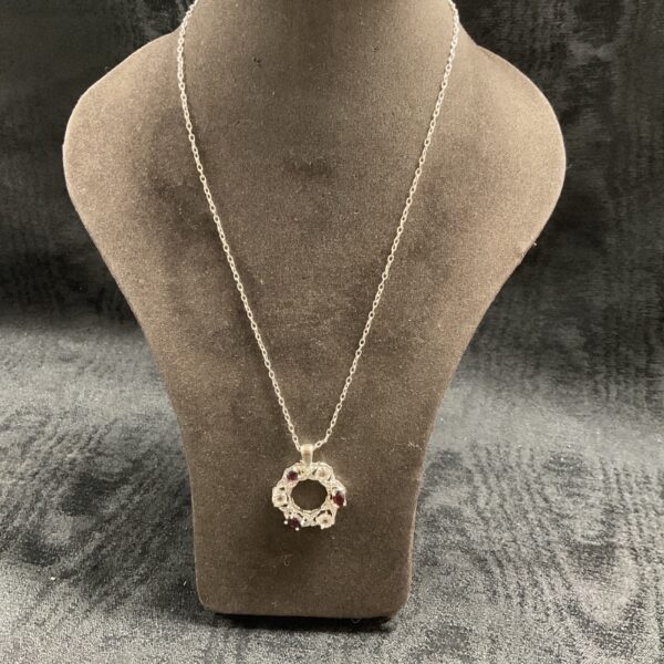 Close-up of a garnet and cubic zirconia necklace pendant.