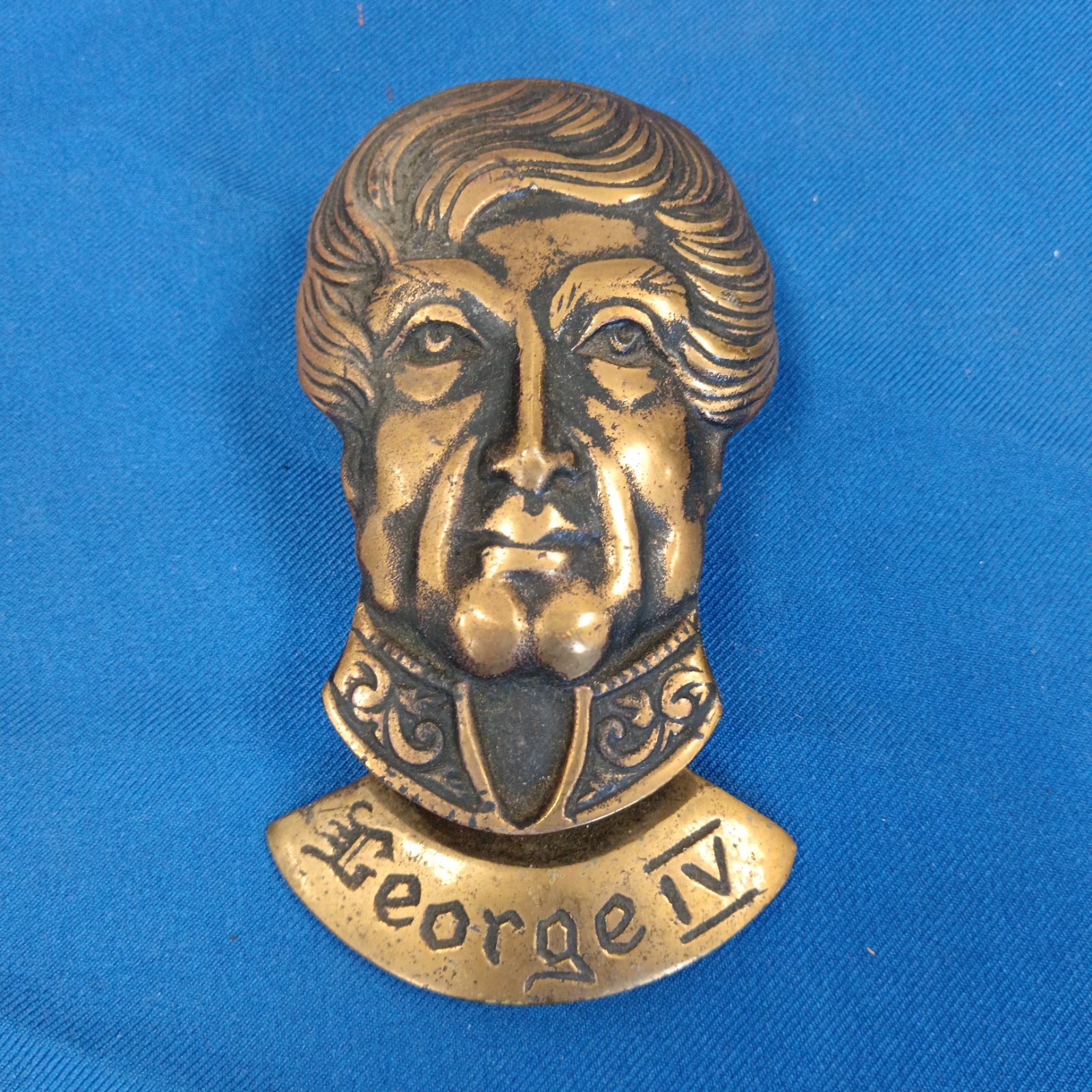 Antique brass George IV door knocker with detailed portrait.