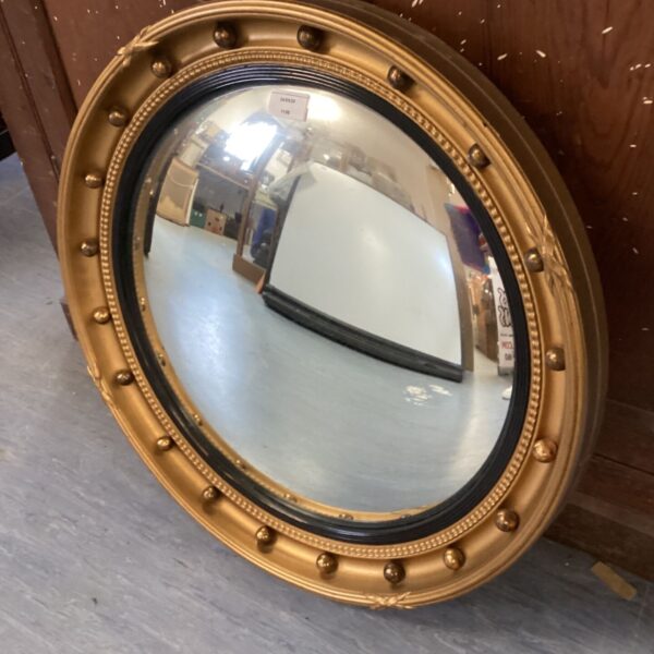 Antique gilt framed convex mirror with a circular shape.
