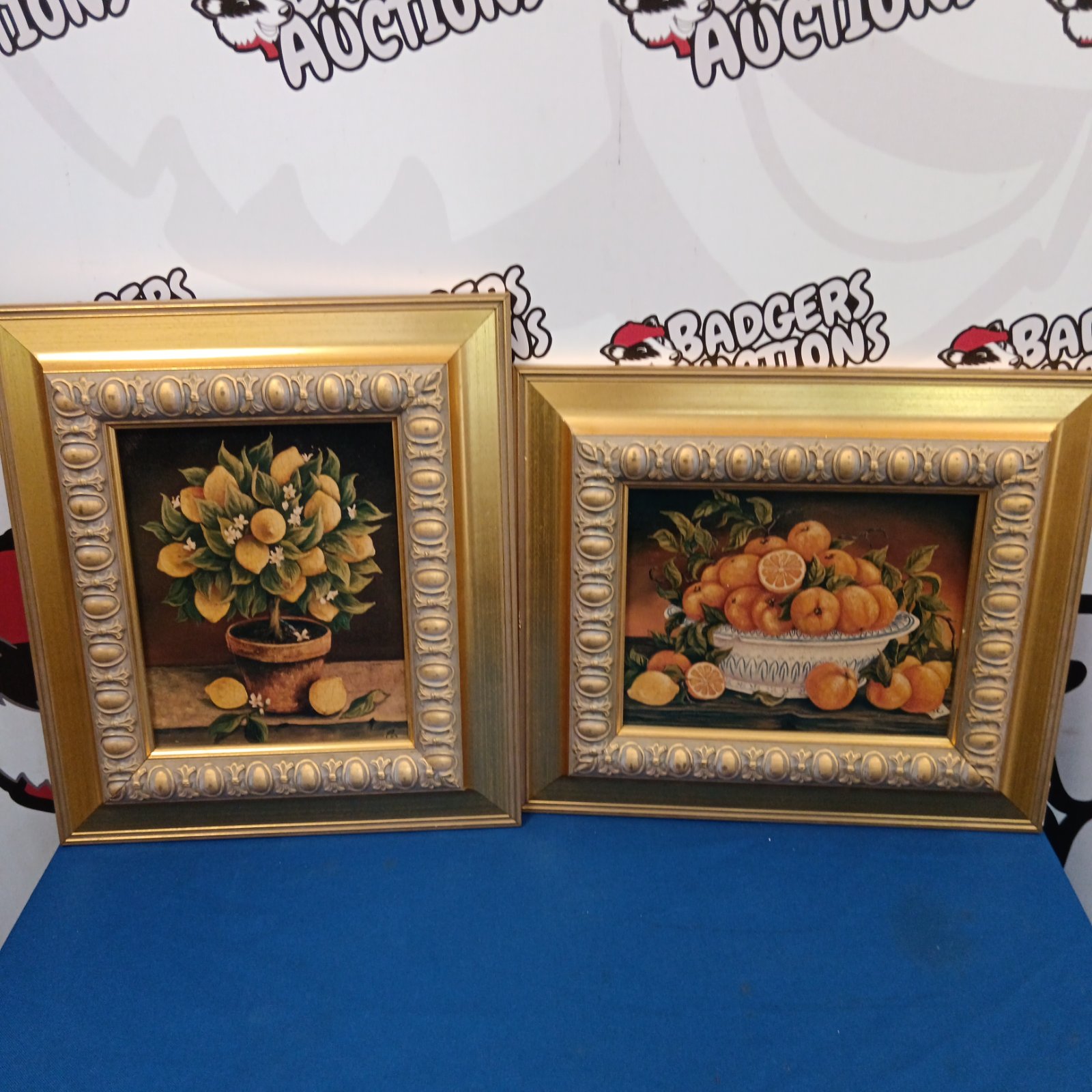 Pair of gilt framed still life prints with fruit and flowers.