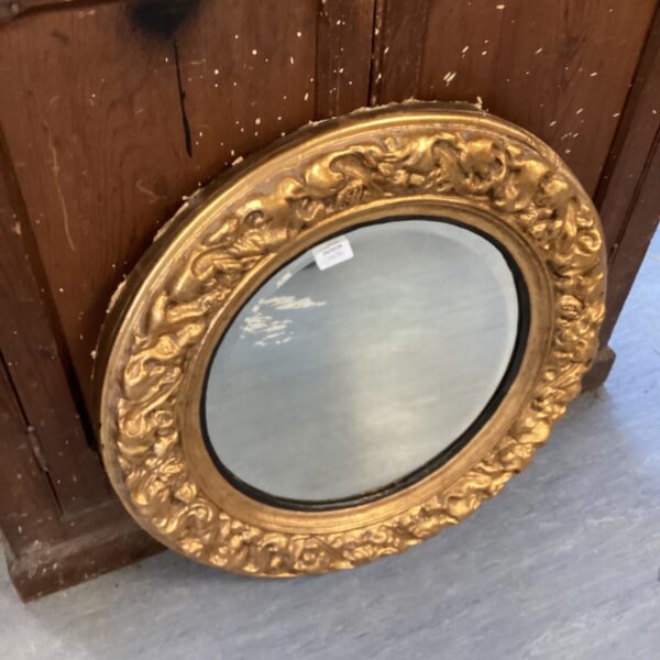 Large antique gilt oval mirror with bevelled glass.