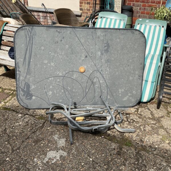Vintage glass top garden table with metal frame.