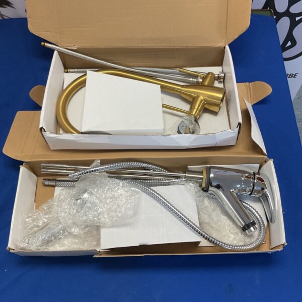 Gold mixer taps in original packaging, modern bathroom fixture.