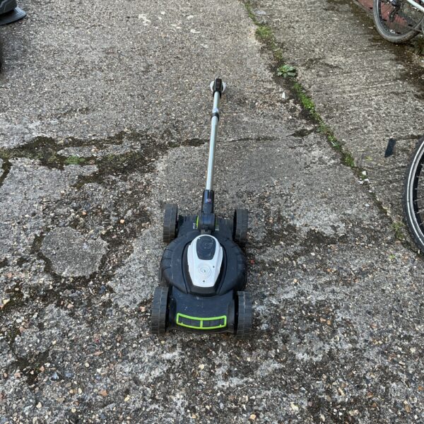 Gtech lawnmower in a garden setting, cordless electric lawn care.