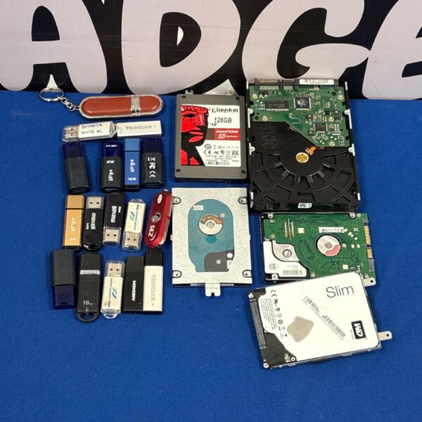 Mixed lot of hard drives and USB sticks for data storage.