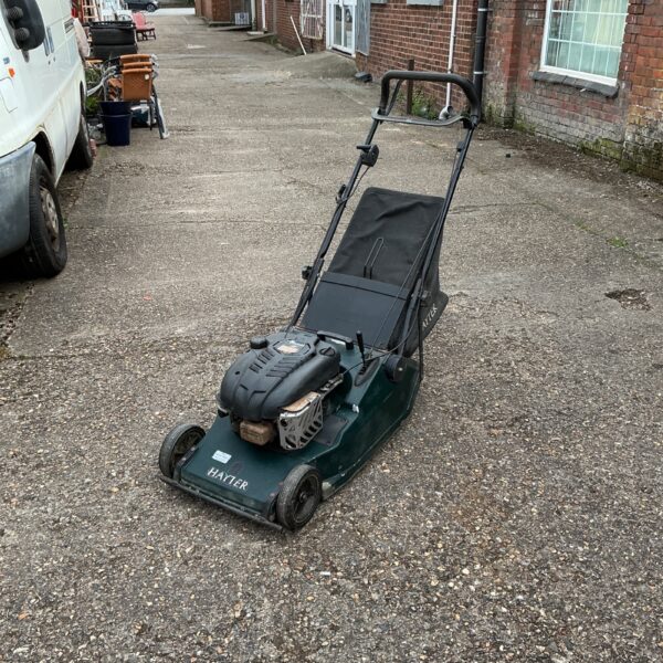 Hayter Harrier 48 petrol lawnmower in a garden setting.
