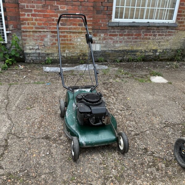 Vintage Hayter petrol lawnmower in a garden setting.