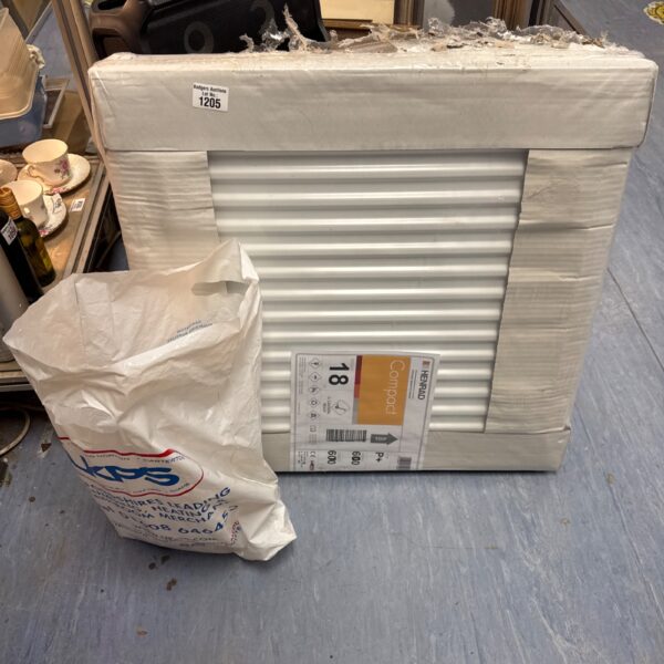 Stack of new Henrad Compact radiators with plumbing connectors.