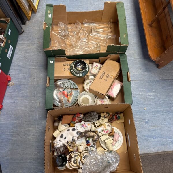 House clearance lot with mixed ornaments and glassware on trays.