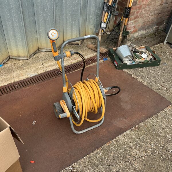 Hozelock hose reel with yellow hose in a garden setting.