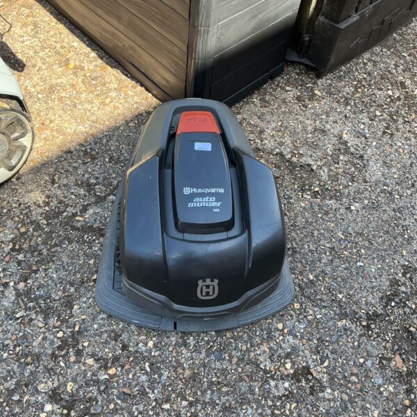 Untested Husqvarna Automower robotic lawnmower in garden setting.