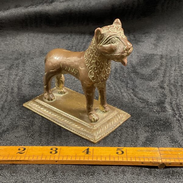 Antique Indo-Persian bronze lion sculpture on a ruler.