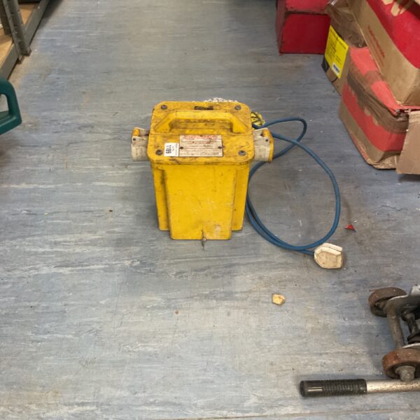 Yellow industrial transformer unit with cable, showing signs of use.