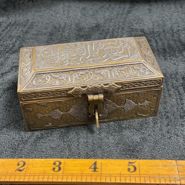 Antique Islamic trinket box with silver inlay, detailed floral patterns.