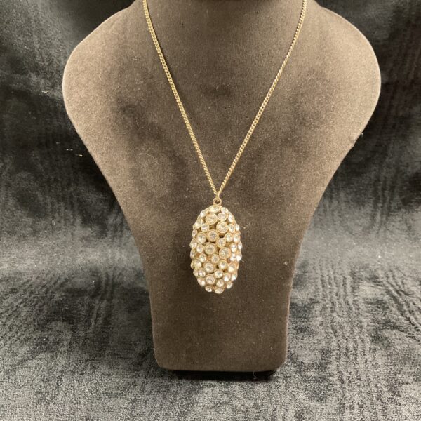Sparkling jewel-encrusted pendant on a 24 inch gold tone necklace.