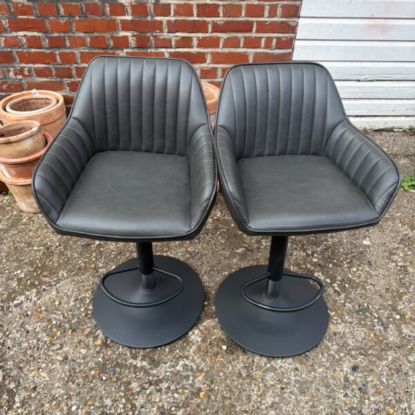 Two John Lewis leather kitchen stools with swivel bases.