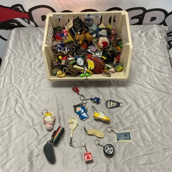 Assorted vintage and collectible keyrings and keychains in a basket.
