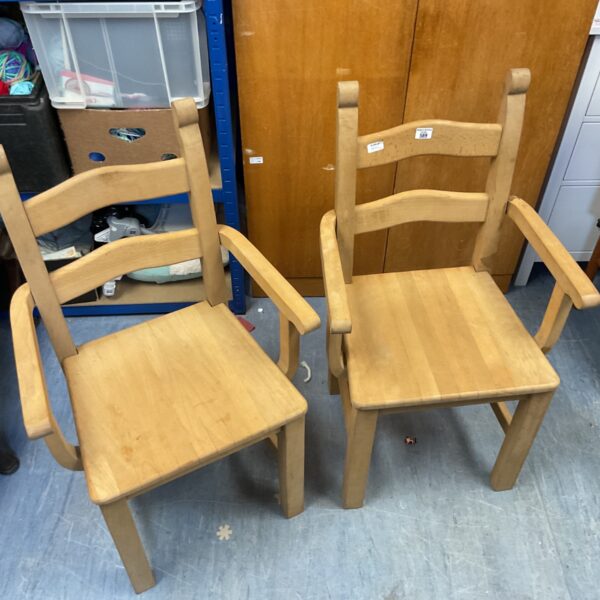 Light wood ladderback armchair with solid seat, vintage farmhouse style.