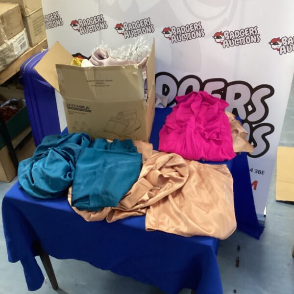 Mixed lot of colourful ladies silk garments on a blue surface.
