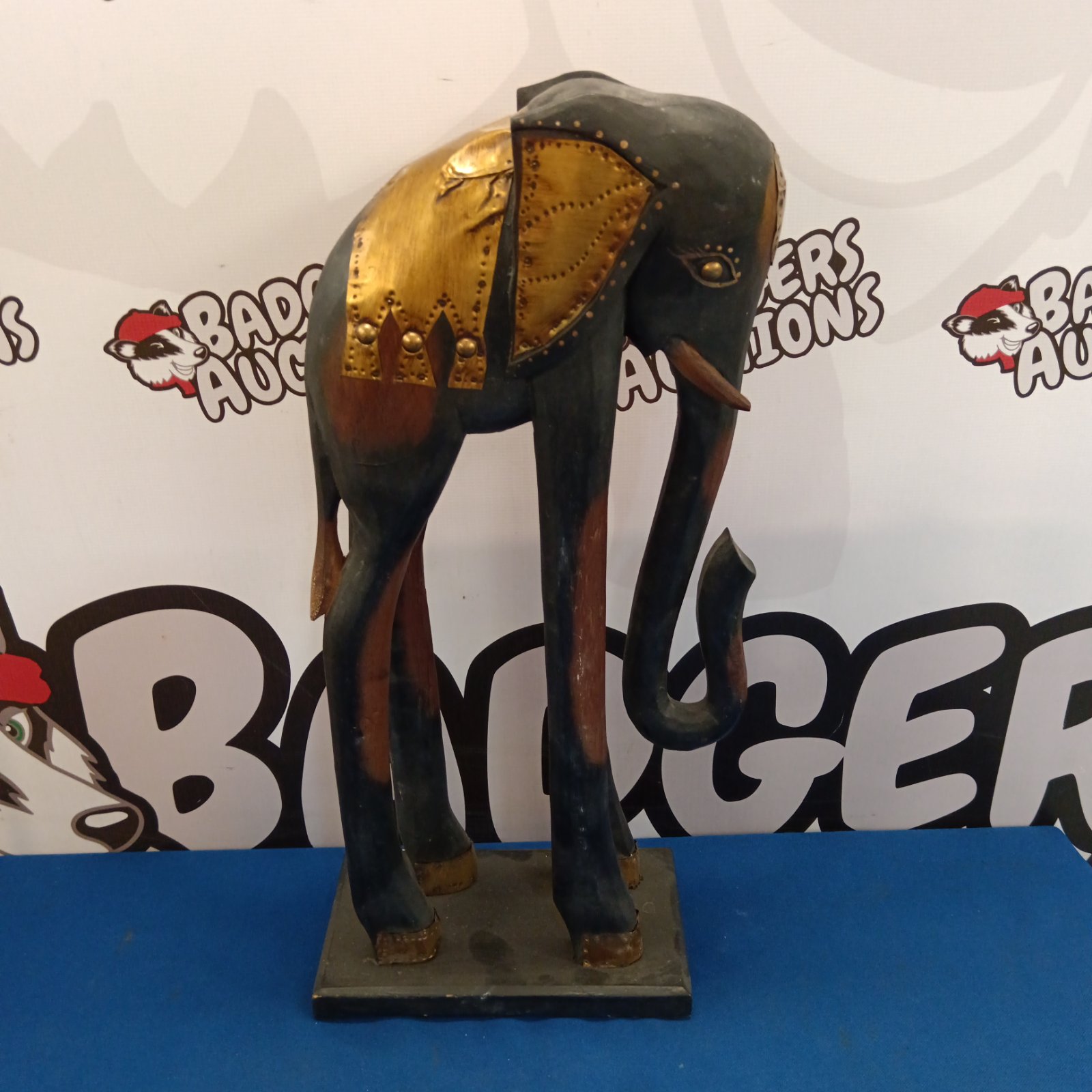 Large carved wooden elephant with decorative painted details.