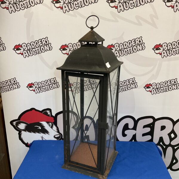 Large metal and glass candle lantern for warm lighting.