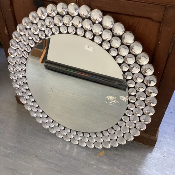 Large round disco ball mirror with shimmering reflective balls.