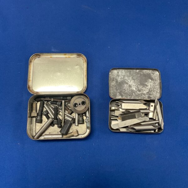 Vintage lathe cutting tools in two metal tins.