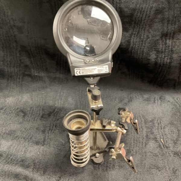 LED magnifying glass with soldering iron holder for electronics work.