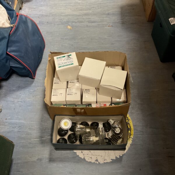 Box of assorted light bulbs and a PIR switch for home lighting.